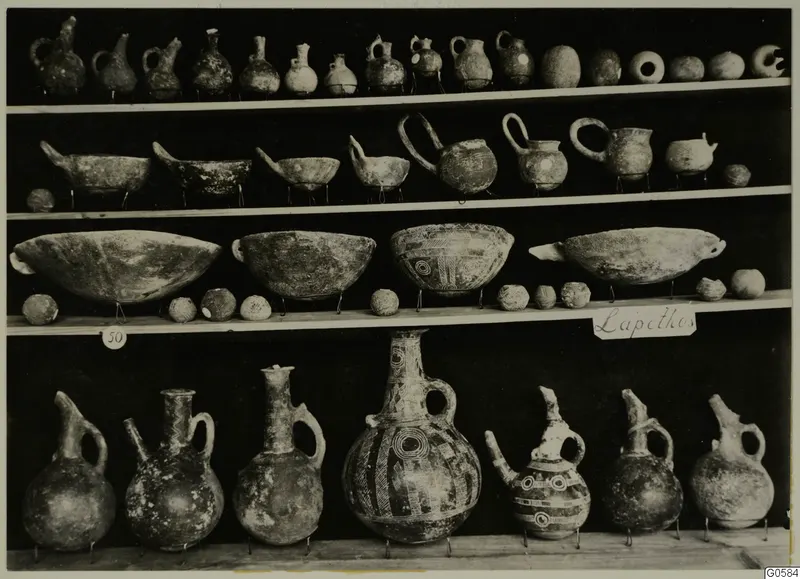 Jugs, bowls and round vessels displayed on wooden shelves, from Lapithos Markides T.50