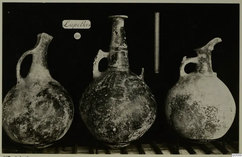 Three round-bodied jugs with side loop handles and tall necks, photographed side by side against a black background, from Lapithos Markides.