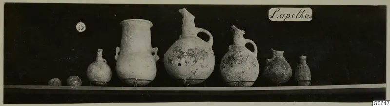 Row of several pottery jars and juglets from Lapithos Markides, T.35, photographed on a shelf.