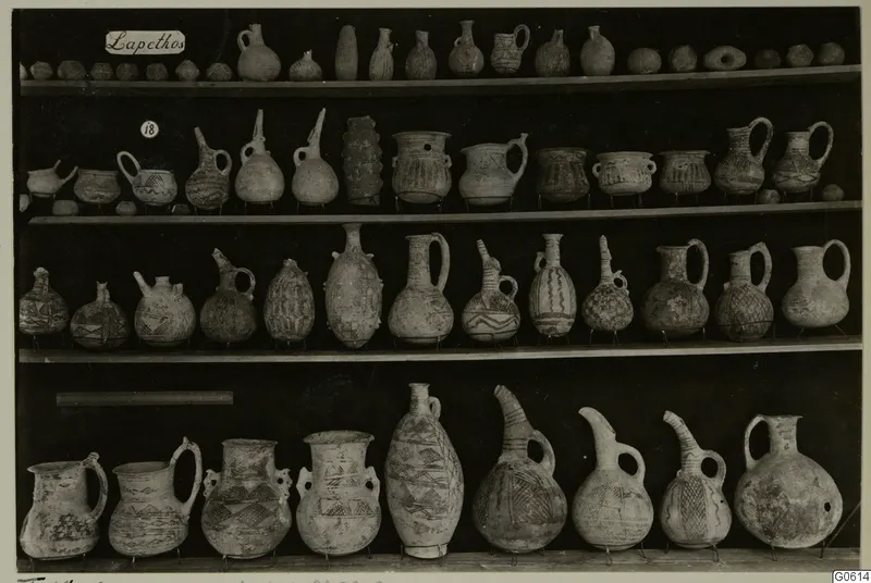Jugs, juglets and bowls from Lapithos Markides, T.18.A, arranged on four wooden shelves