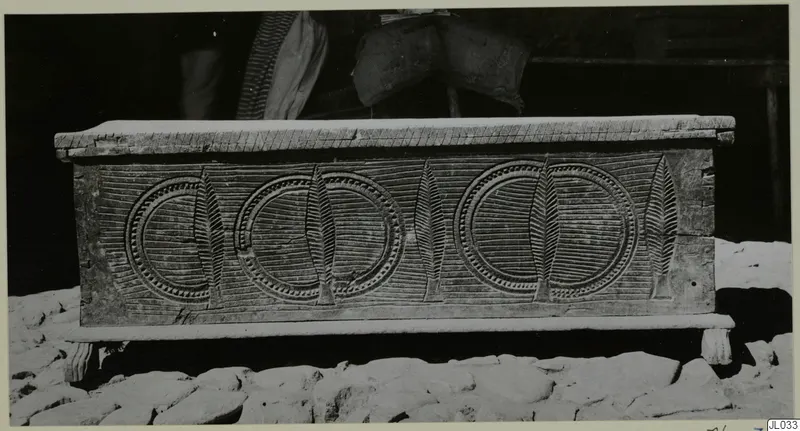 Carved wooden clothes chest, so-called sendudzin, standing on a stone-paved ground