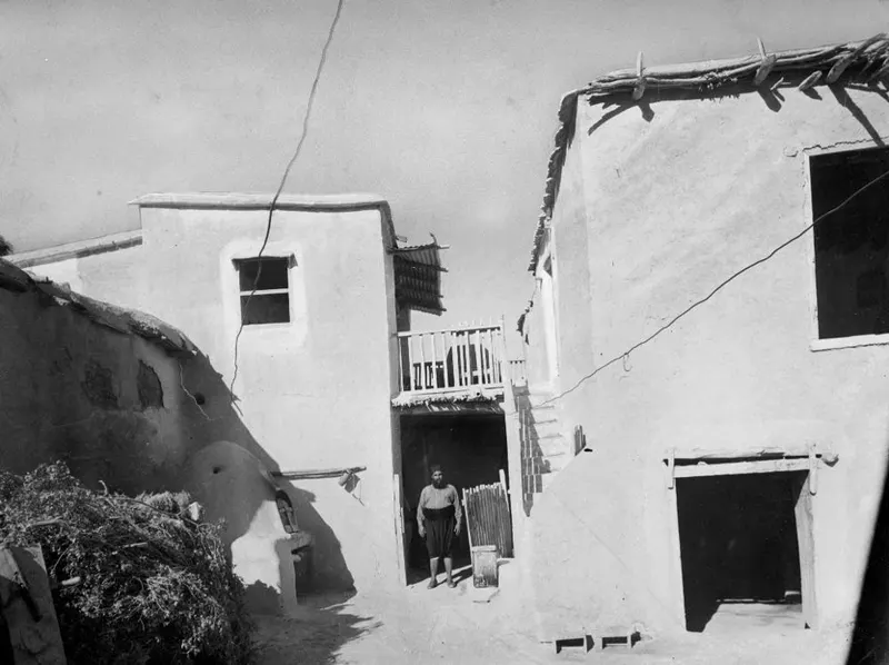 Whitewashed houses at Mándres with a man standing in a doorway between them