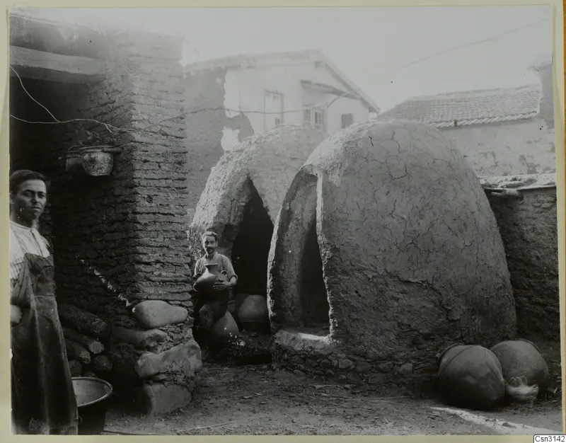 Two domed clay kilns in a potter's yard at Klirou, with two people standing nearby.