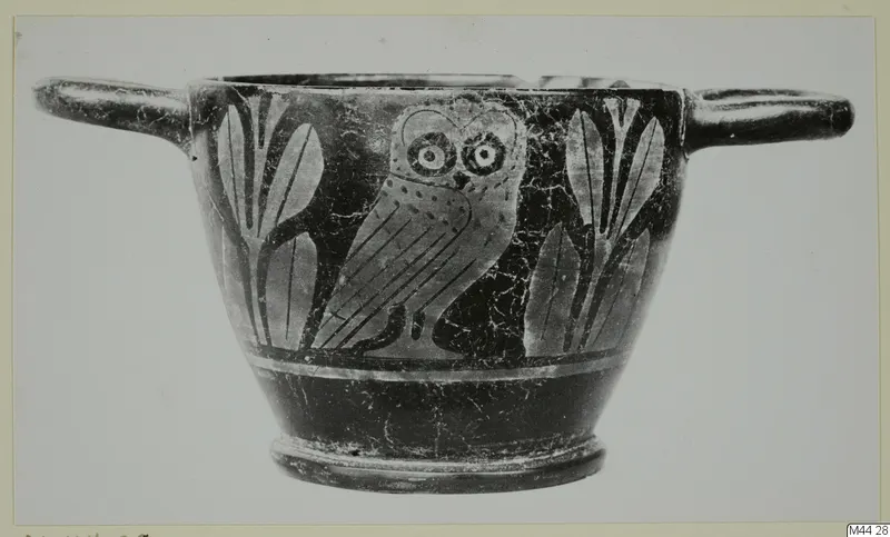 Two-handled black-glazed cup with a painted owl between upright leaf motifs