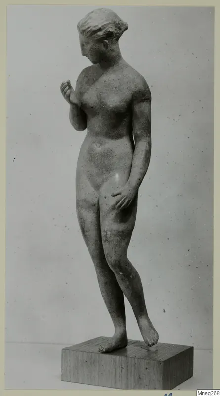 Standing female nude statue in stone, shown on a wooden block base against a plain grey background