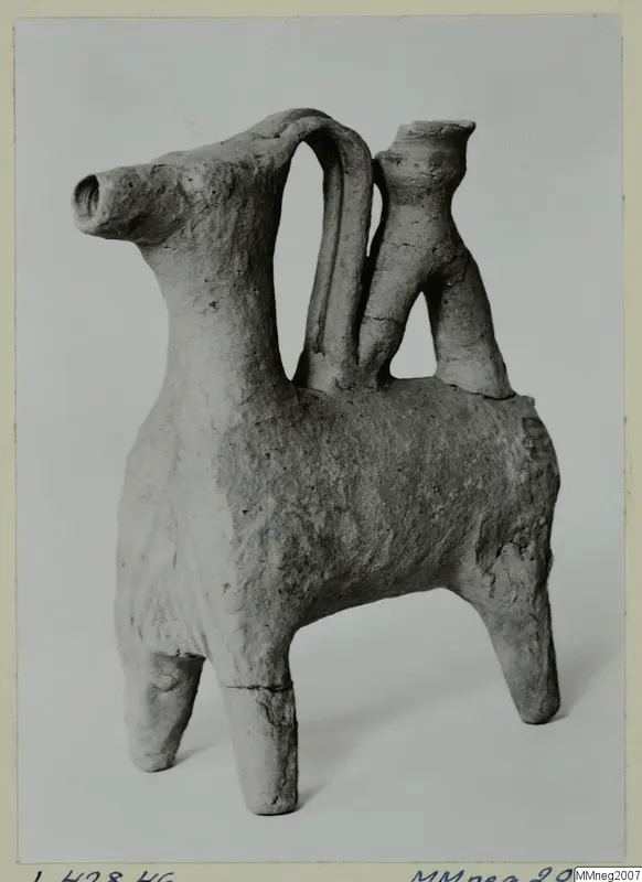 Clay vessel shaped like a four-legged animal, with a tall arched handle and a small spout rising from its back