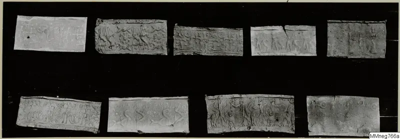 Nine rectangular pieces with raised or incised designs, laid out in two rows on a black background.