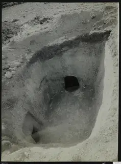 Tomb 314 at Lapithos during excavation, with the tomb chamber opening visible in the cut face