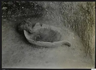Tomb 305 at Lapithos: a broken vessel lying in a rock-cut tomb chamber during excavation.