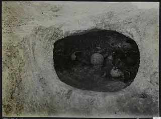 Tomb 305 at Lapithos seen from above during excavation, with pottery vessels lying inside the tomb chamber.