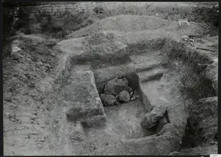 Excavated dromos of Tomb 303 at Vrysi tou Barba, Lapithos, with stone blocks in the cut and tools at the edge