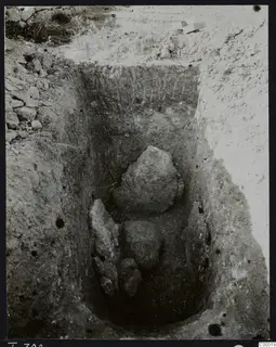 Excavated tomb chamber at Lapithos, Vrysi tou Barba, with large stones lying inside the cut.