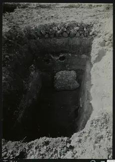Excavated tomb chamber at Lapithos, Vrysi tou Barba, with a large stone lying in the pit