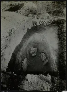 Tomb 313 at Lapithos, Vrysi tou Barba: excavated tomb chamber with rocks and grass during excavation