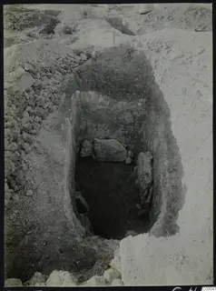 Tomb 313 at Lapithos, Vrysi tou Barba, during excavation: a cut pit with large stones inside and spoil heaps around it.
