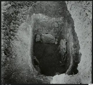 Excavated tomb chamber 313 at Lapithos, Vrysi tou Barba, with large stones lying in the pit during excavation