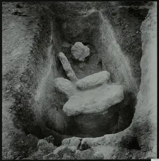 Tomb 322 at Lapithos, Vrysi tou Barba: excavated chamber with pale limestone slabs and blocks in the base.