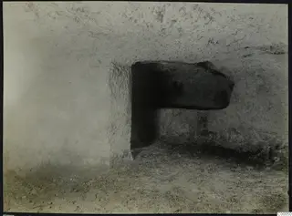 Tomb chamber at Vrysi tou Barba, Lapithos, with a large stone lying in a rectangular opening in the rock wall