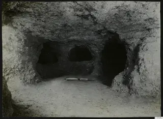 Interior of rock-cut Tomb 313 A at Lapithos, Vrysi tou Barba, with three recesses in the back wall and two flat stones on the floor