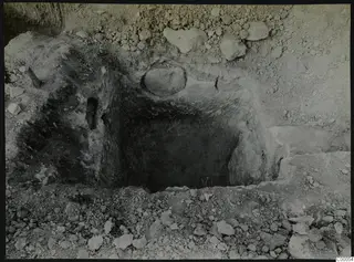 Tomb 316 at Lapithos, Vrysi tou Barba, during excavation, showing the open tomb chamber among loose stones.