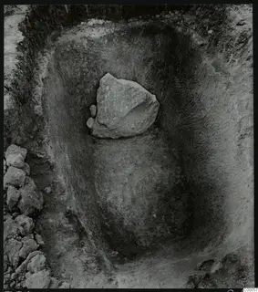 Tomb 318 at Lapithos during excavation, with a large stone lying in the cut of the tomb chamber