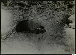 Rock-cut tomb chamber opening at Lapithos, Vrysi tou Barba, with stones and objects during excavation