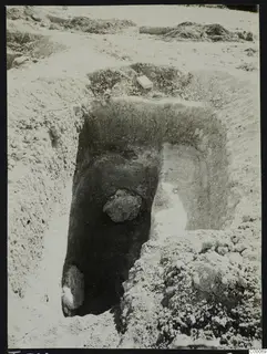 Excavated tomb 308 at Lapithos, Vrysi tou Barba, with a large stone inside the chamber and a pale box on the spoil above it