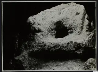 Rock-cut surface of Tomb 306 at Lapithos, Vrysi tou Barba, during excavation, with a small dark opening