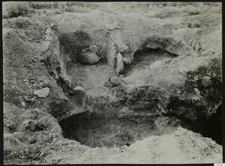 Excavated tombs 320 and 323 at Vrysi tou Barba, Lapithos, with cut earth sides and stones on the floor