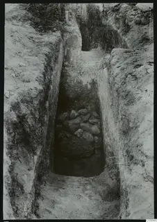Tomb 413 at Lapithos during excavation: a narrow cut with a rough stone fill at its far end