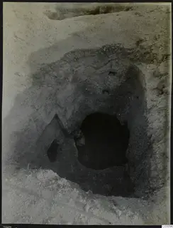 Tomb 306 at Lapithos, Vrysi tou Barba, during excavation, showing the dark opening of the tomb chamber in the excavated soil