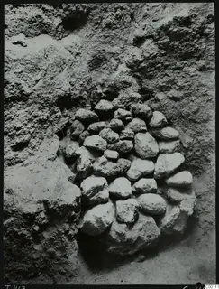 Stones packed into the doorway of Tomb 417 at Lapithos, set into a rough earthen cut face.