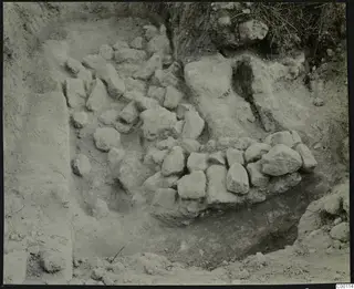 Tomb 412 at Lapithos Kastros during excavation, with rough stones set in an excavated cut