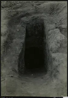 Tomb 402 at Lapithos Kastros during excavation, seen from the sloping cut leading to the dark tomb chamber entrance.