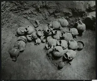 Pottery vessels lying in situ on the earth floor of Tomb 417 at Lapithos, against the rock wall of the chamber