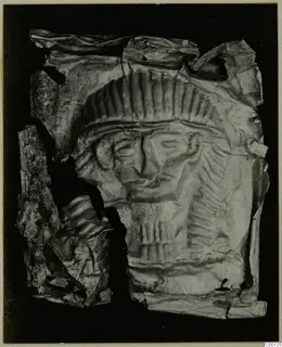 Torn, crumpled thin metal sheet with an embossed face and rows of ridges, Bronze Age gold and silver