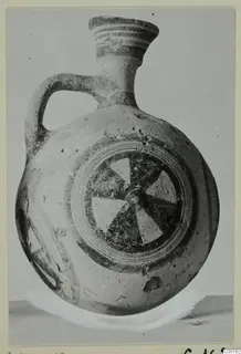 White Painted I jug with a strap handle, banded neck and a pinwheel motif on the body