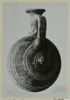 Pottery flask with a flat-rimmed neck, a loop handle and concentric circle painting on its round body