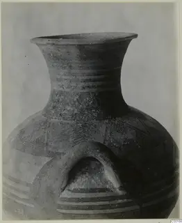 Striped pottery amphora from Lapithos, shown close up with a wide flaring neck and an arched handle.
