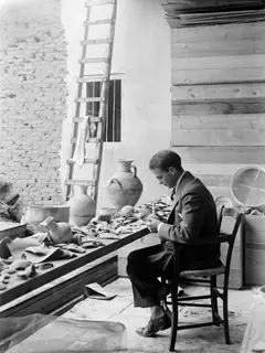 Erik Sjöqvist seated at a table of broken pottery and jugs in Nicosia