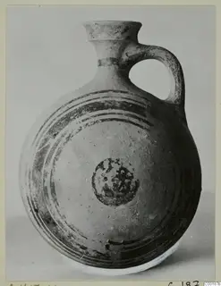 White Painted I jug with a flared neck, single loop handle and dark concentric bands on the body