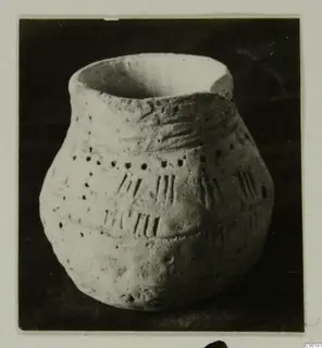 Coarse hand-made pottery jar with incised strokes and rows of small pierced dots