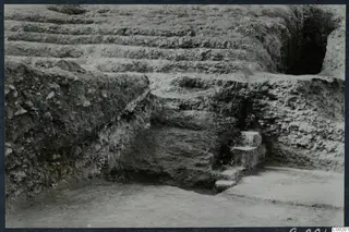 Excavated stone steps at the theatre at Soli, with earth terraces rising behind them.