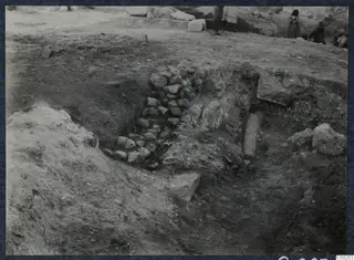 Excavation at the theatre at Soli, with a rubble stone wall and a column drum lying in the trench