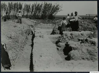 Excavated trench with Byzantine walls at Soli, with workers and a girl standing among the stonework