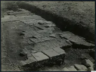 Excavated stone paving or floor at Soli, with flat slabs and smaller stones set in a trench