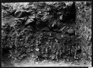 Excavated soil face at the theatre at Soli, with stones and rubble set in layers of earth.