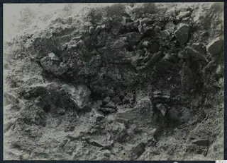 Excavated earth face with stones embedded in it, at the theatre at Soli