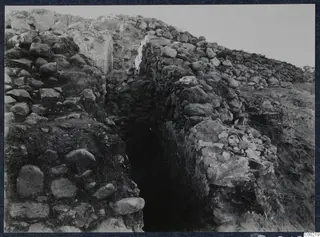 Rough stone walls with a narrow dark opening between them at Soli.