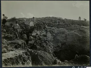 Excavation of the substructure walls of the east eisodos at the Soli theatre, with workers among rubble stone walls.